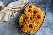 Pizza bread with tomatoes and herbs in a fireproof dish