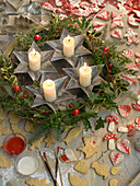 Stillleben mit Weihnachtskranz aus Stechpalme und Fichte, umgeben von Weihnachtsplätzchen