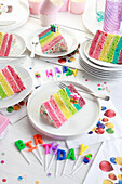Rainbow cake cut into pieces and served on plates