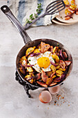 Gröstl with fried egg, sausage, and red onions