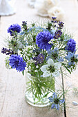 Small bouquet of flowers in blue and white with lavender, cornflowers and maiden in the green