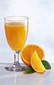 Ein Glas Apfelsinensaft und Apfelsinen