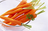 Bowl with peeled carrots on a light background
