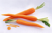 Three peeled carrots on a light background