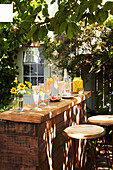 Drinks on a wooden counter in a summery backyard