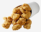 A generic serving container of deep fried breaded chicken nuggets on a white background