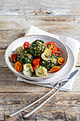 Spinach and feta cakes with baked tomatoes and artichoke hearts