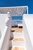 Stairs to the covered terrace with lounge furniture