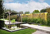 Garden pond and seating area under a pergola (Appeltern, Netherlands)