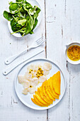 Slices of thin scallop with mango carpaccio and mango dressing