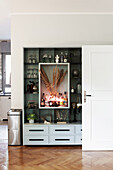 Built-in shelving with dried flowers, home bar and lighting