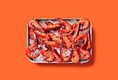 Prawns on ice against a coloured background