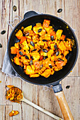 Vegan potato pumpkin curry with mango strips and golden raisins