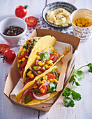 Tacos with shredded beef, corn, and tomatoes
