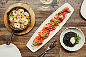 Plates of Spanish tapas. Garlic prawns, octopus and black rice
