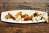 A selection of cheese with toasted bread, walnuts and chilli dipping sauce
