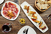 Spanischer Serrano-Schinken, Käseplatte, Oliven und frisches Brot mit Rotwein