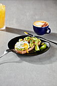 Smashed avocado with a poached egg on sourdough with coffee and orange juice