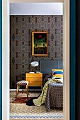 Blick ins Schlafzimmer - Tapete mit geometrischem Muster, Kunstwerk über Nachtschränkchen und Bett