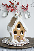 Gingerbread houses with sugar pearls and hanging vases with holly berries