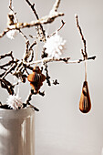 Branches in a vase with paper ornaments hanging from them