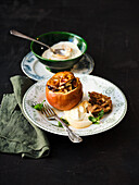 Baked apple with dried fruits, walnuts and maple syrup cream