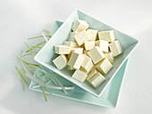 Bowl with tofu cubes on a light background