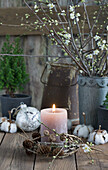 Plum blossom twigs in a zinc pot, honey candle with a larch wreath, cones, Christmas ornaments