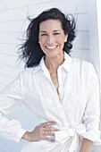 Mature dark-haired woman in white dress with embroidery