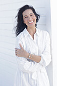 Mature dark-haired woman in white dress with embroidery