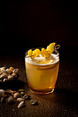 Whiskey sour cocktail with lemon and pistachio nuts