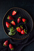 Frische Erdbeeren auf schwarzem Teller