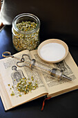 Tea herbs, old book and syringe