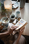 Woman reading a book at the breakfast table