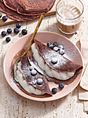Cocoa crêpes with curd filling and blueberries