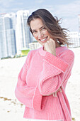 A long-haired woman wearing a pink jumper