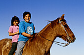 Native American Hopi children riding a horse