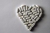 White pills arranged in a heart shape