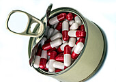 Can full of white and red capsules, conceptual image