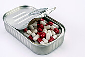 Can full of white and red capsules, conceptual image