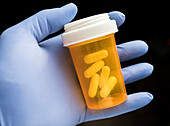 Doctor holding a container of pills
