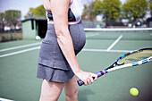 Pregnant woman playing tennis on tennis court