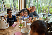 Father feeding toddler daughter at cabin dining table