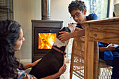 Boy petting dog by fireplace