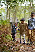 Happy brothers hiking on trail in woods