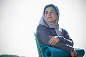 Young woman in hijab with yoga mat