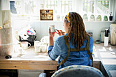 Young female artist painting ceramics in art studio