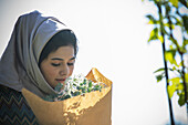 Woman in hijab smelling flower bouquet