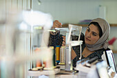 Muslim seamstress preparing spools of thread