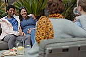 Pregnant couple hanging out with friends on patio